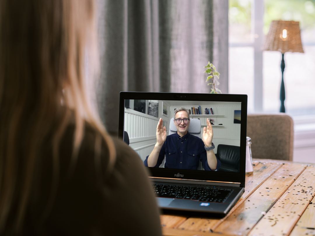 Kvinna som tittar på en skärm med Jonas Höglund som pratar