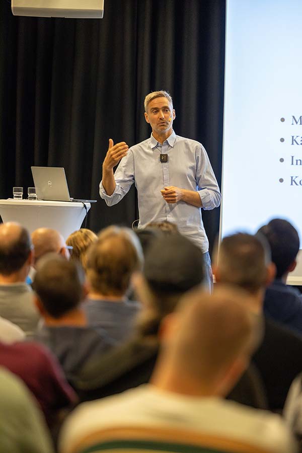 Jonas Höglund on stage in front of a seated audience, presenting how the brain works