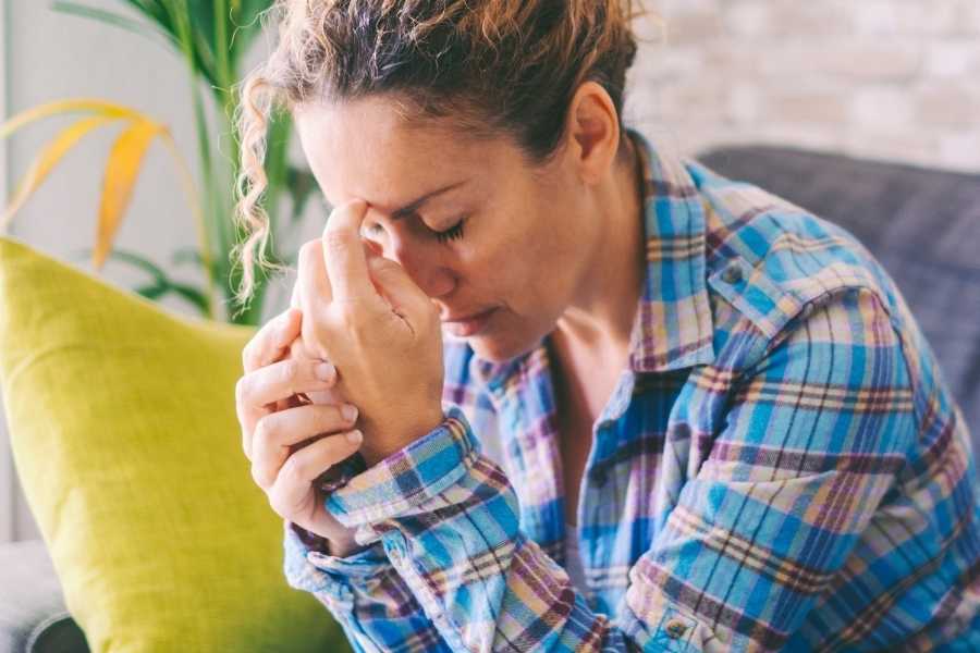 Social ångest Kvinna som sitter med händerna för pannan